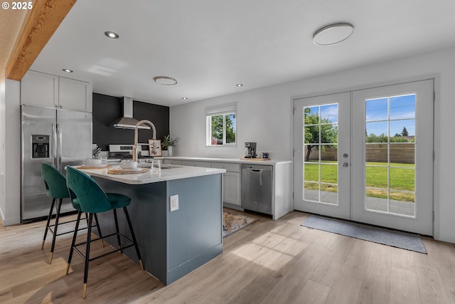 605 SE 104th Ave, Vancouver, WA 98664 - kitchen with appliances with stainless steel finishes, french doors, light countertops, light wood-style floors, and a breakfast bar