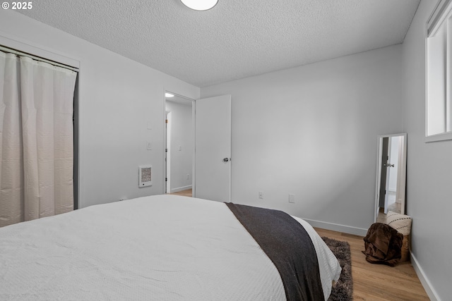605 SE 104th Ave, Vancouver, WA 98664 - bedroom with wood finished floors, a textured ceiling, heating unit, and a closet