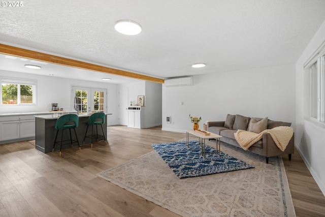 605 SE 104th Ave, Vancouver, WA 98664 - living room featuring light wood-style flooring, a wall mounted air conditioner, and beam ceiling