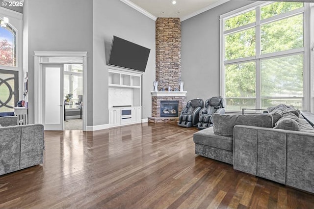 2021 Pikes Pass Ct, Salem, OR 97306 - living area featuring ornamental molding, dark wood-style floors, built in features, a stone fireplace, and plenty of natural light