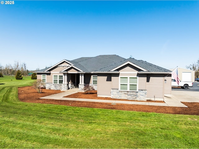 view of front of property with stone siding, roof with shingles, and a front lawn