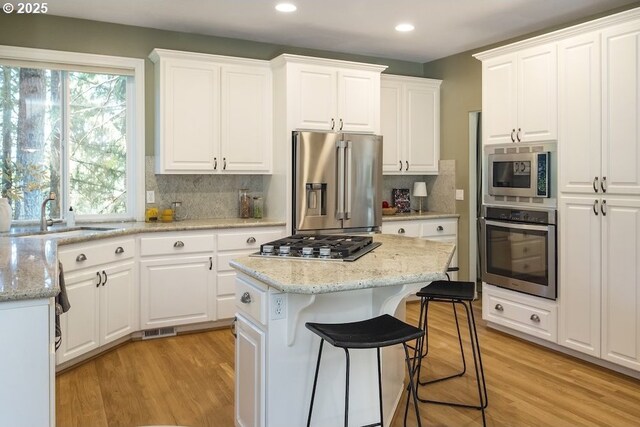 13037 SW Ascension Dr, Portland, OR 97223 - kitchen featuring appliances with stainless steel finishes, recessed lighting, a sink, white cabinetry, and backsplash