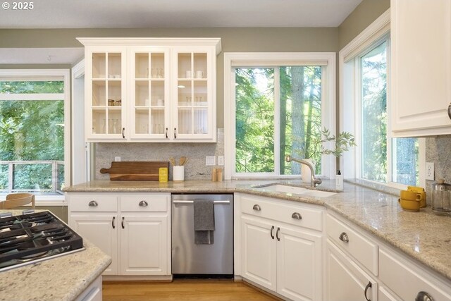 13037 SW Ascension Dr, Portland, OR 97223 - kitchen with appliances with stainless steel finishes, a sink, backsplash, glass insert cabinets, and white cabinetry