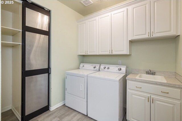 13037 SW Ascension Dr, Portland, OR 97223 - laundry area with washing machine and clothes dryer, cabinet space, light wood finished floors, and baseboards