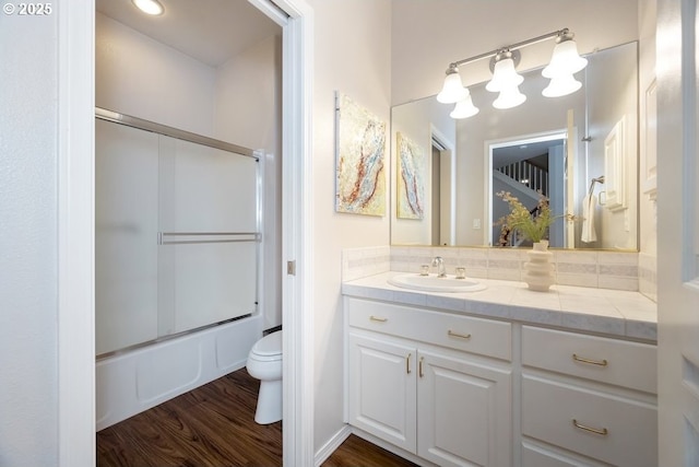 13037 SW Ascension Dr, Portland, OR 97223 - bathroom featuring vanity, toilet, wood finished floors, combined bath / shower with glass door, and tasteful backsplash