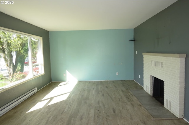 1817 Shamrock Dr, Centralia, WA 98531 - unfurnished living room featuring a baseboard radiator, wood finished floors, and a brick fireplace