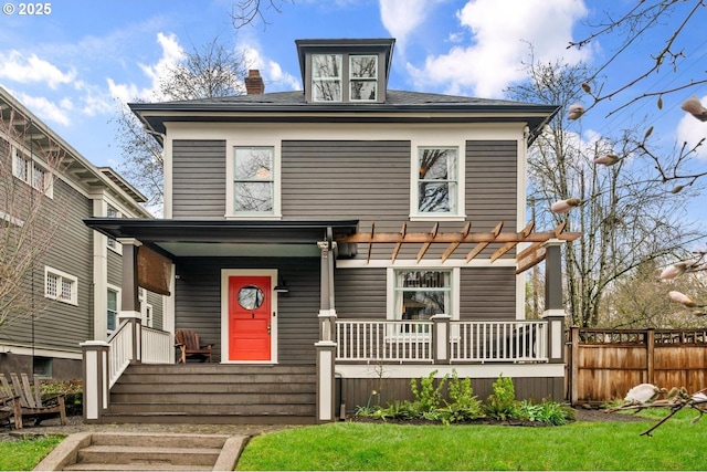 american foursquare style home featuring a front yard, fence, a porch, a pergola, and a chimney