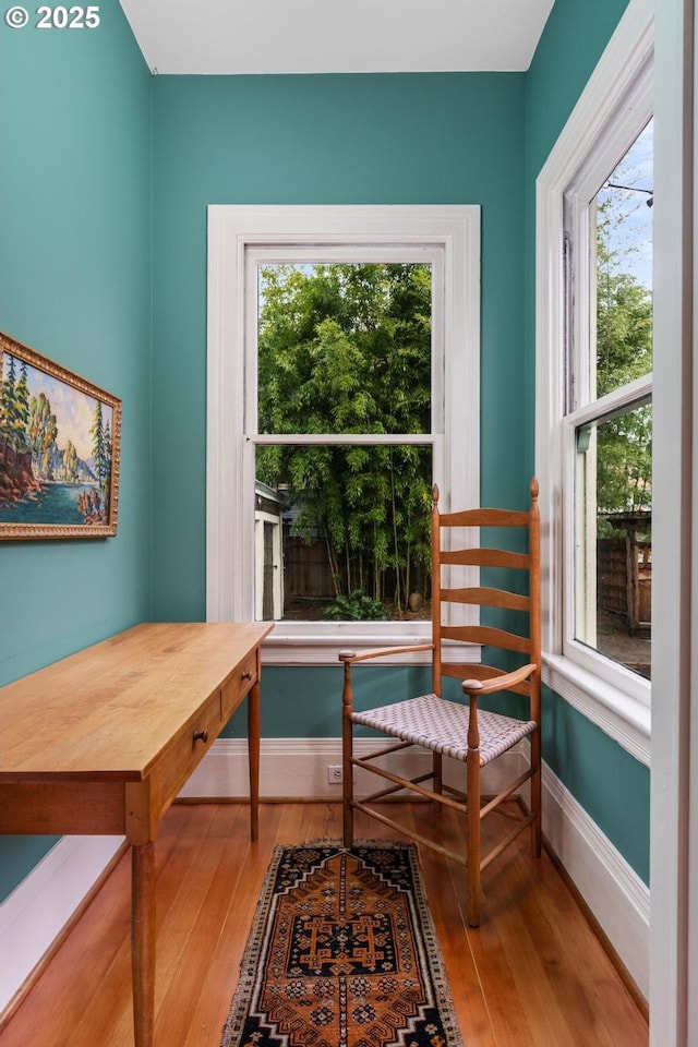 sitting room with baseboards and wood-type flooring