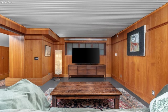 living room featuring wooden walls and finished concrete flooring