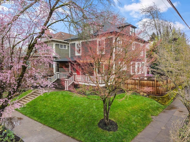 traditional style home with a front lawn, stairway, fence, and covered porch