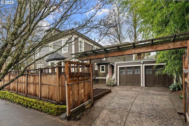 view of side of property with a garage, driveway, and fence