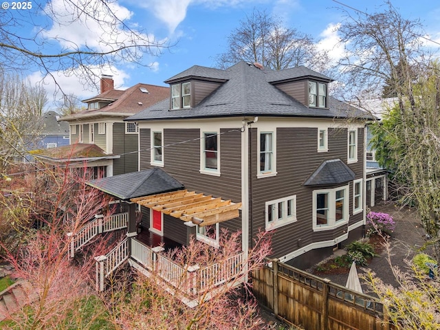 back of property with roof with shingles