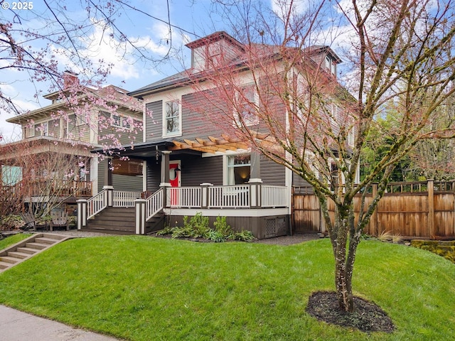 traditional style home with a front lawn, fence, and covered porch