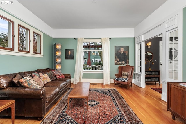 living area with baseboards and wood finished floors