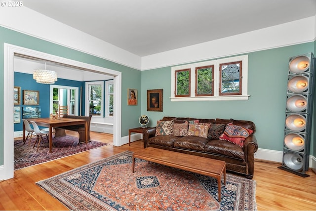 living room featuring wood finished floors, baseboards, and a chandelier