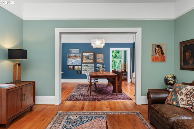 office space with light wood-type flooring, baseboards, and an inviting chandelier