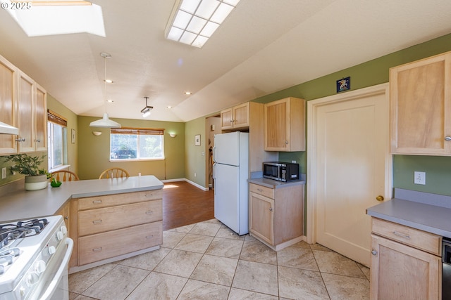 kitchen featuring white appliances, light brown cabinets, vaulted ceiling, a peninsula, and light countertops