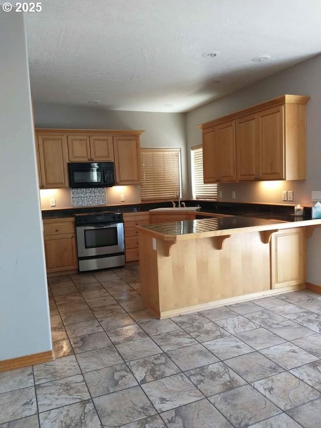 931 SW Joseph Ave, Hermiston, OR 97838 - kitchen featuring stainless steel electric range, black microwave, light marble finish floors, and dark countertops