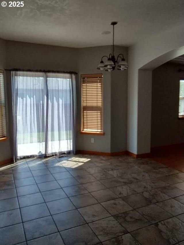931 SW Joseph Ave, Hermiston, OR 97838 - spare room with a chandelier, arched walkways, and tile patterned floors