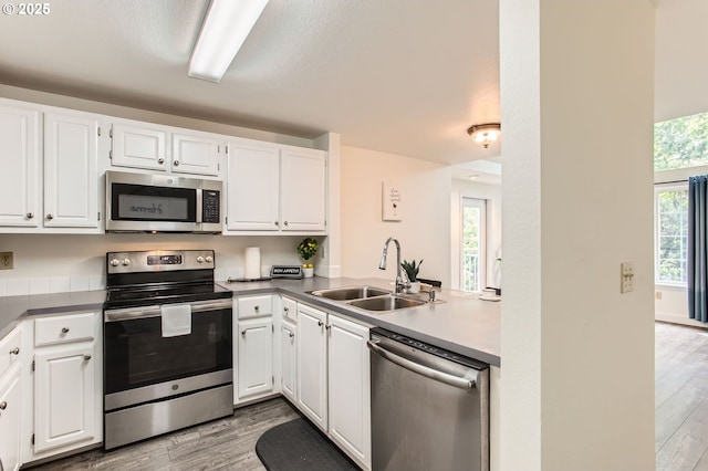 17532 NW Springville Rd Unit D8, Portland, OR 97229 - kitchen with stainless steel appliances, light wood-style flooring, and white cabinets