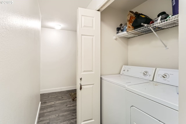 clothes washing area featuring baseboards, separate washer and dryer, laundry area, and wood finished floors