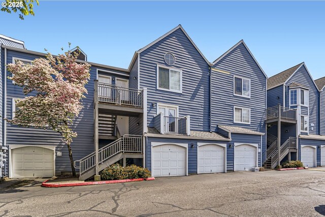 townhome / multi-family property featuring a garage, a balcony, and stairway