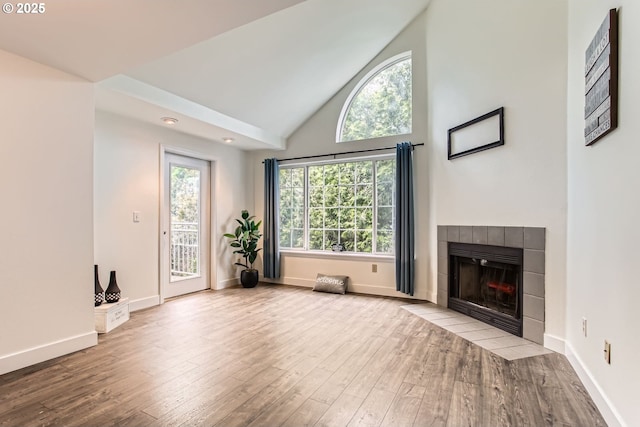 17532 NW Springville Rd Unit D8, Portland, OR 97229 - unfurnished living room with a tile fireplace, hardwood / wood-style flooring, and high vaulted ceiling