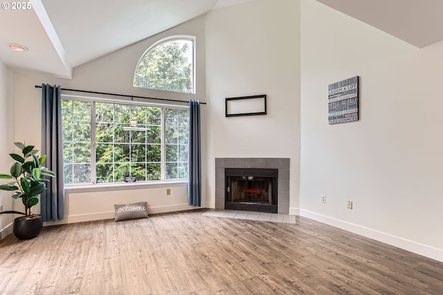 17532 NW Springville Rd Unit D8, Portland, OR 97229 - unfurnished living room with plenty of natural light, wood finished floors, a fireplace, and high vaulted ceiling