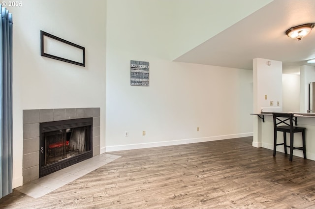 17532 NW Springville Rd Unit D8, Portland, OR 97229 - unfurnished living room featuring wood finished floors and a tiled fireplace