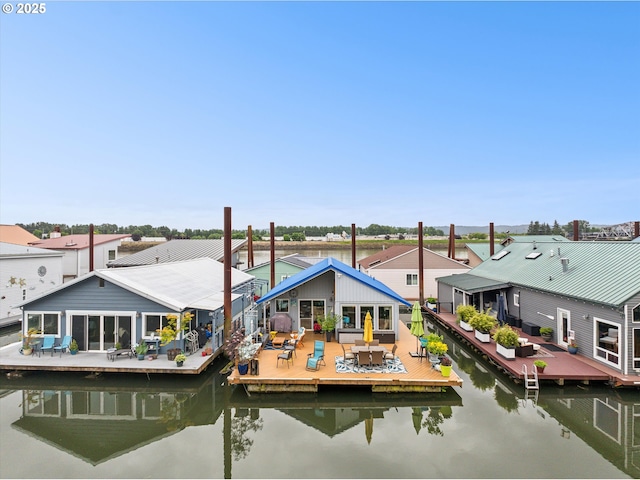 rear view of house featuring a water view and outdoor dining area