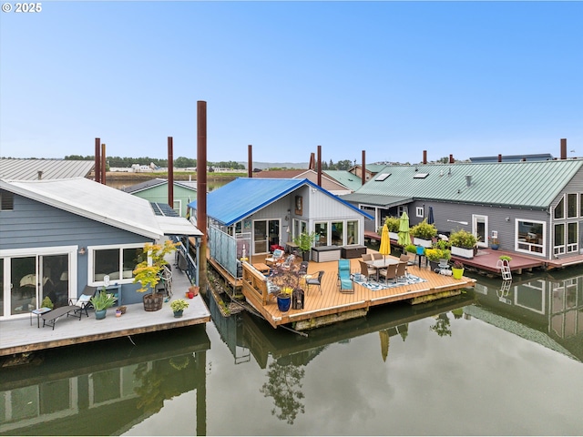 dock area featuring a deck with water view and outdoor dining space