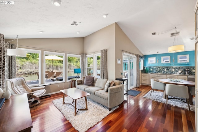 living room featuring visible vents, a healthy amount of sunlight, and hardwood / wood-style flooring