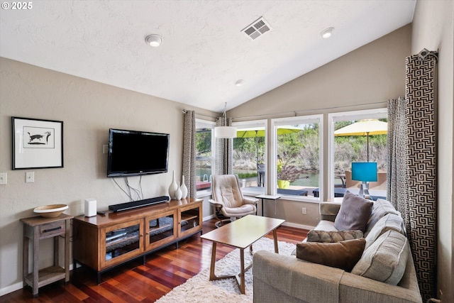 living area with visible vents, baseboards, dark wood-style flooring, and lofted ceiling