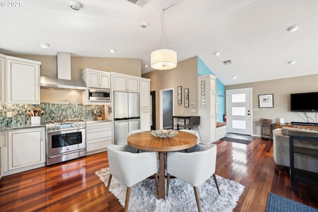 dining area with visible vents, dark wood-style floors, and lofted ceiling