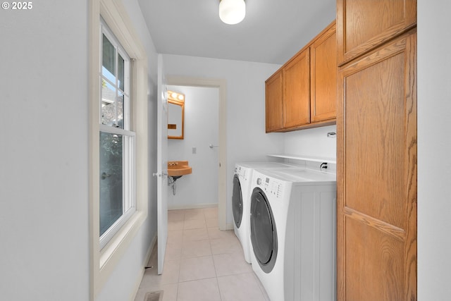 laundry area with light tile patterned flooring, cabinets, sink, and washing machine and dryer