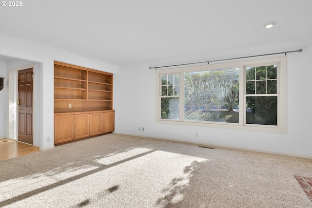 unfurnished living room with light colored carpet