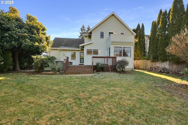 rear view of property featuring a deck and a lawn