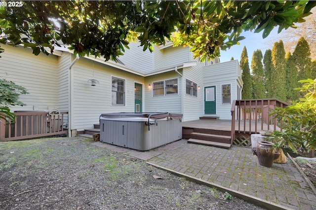 back of property featuring a hot tub, a deck, and a patio