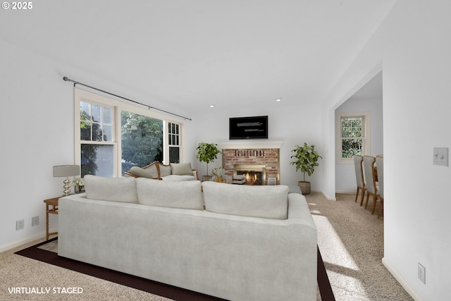 living room featuring carpet flooring and a brick fireplace