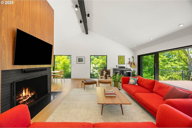 2930 NW Quimby St, Portland, OR 97210 - living area with a large fireplace, healthy amount of natural light, beamed ceiling, wood finished floors, and high vaulted ceiling