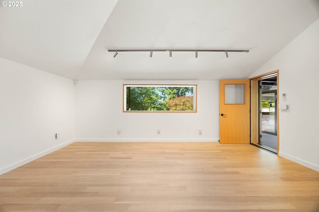 2930 NW Quimby St, Portland, OR 97210 - empty room featuring rail lighting, lofted ceiling, plenty of natural light, and light wood finished floors