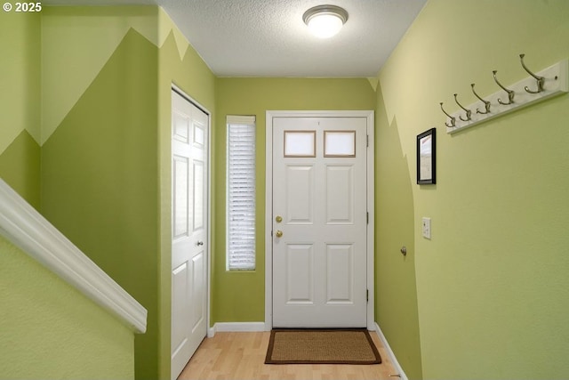 foyer featuring light wood-type flooring and a textured ceiling