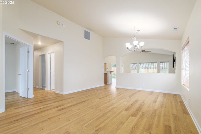 5470 Jeffrey Way, Eugene, OR 97402 - unfurnished living room featuring arched walkways, a chandelier, light wood-type flooring, and healthy amount of natural light