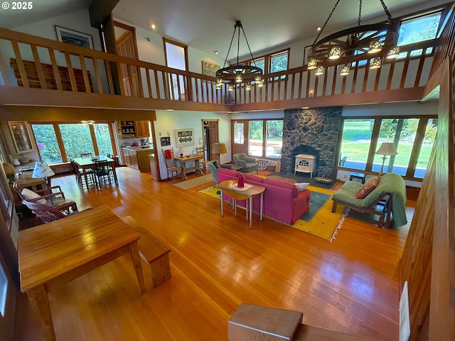 living room featuring a chandelier, a towering ceiling, recessed lighting, and wood finished floors