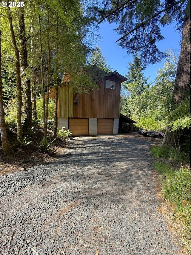 exterior space with an attached garage, an outbuilding, and driveway