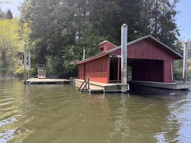 dock area featuring a wooded view and a water view