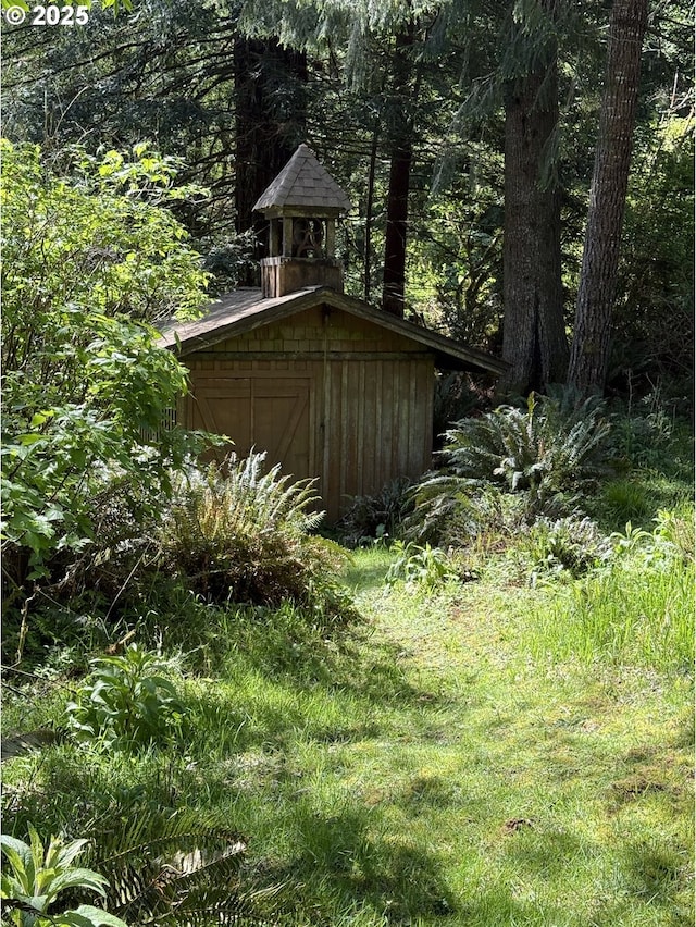 view of shed featuring a view of trees