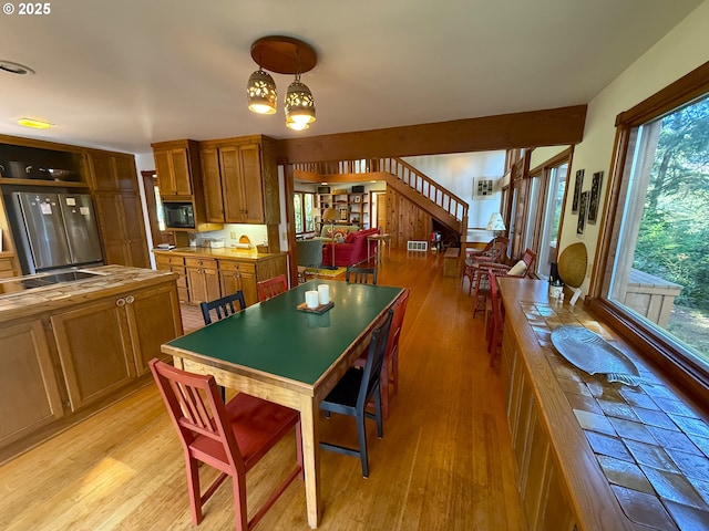 dining room featuring visible vents, light wood-style flooring, stairway, and a notable chandelier
