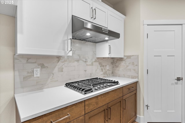 kitchen with backsplash, white cabinetry, and stainless steel gas stovetop