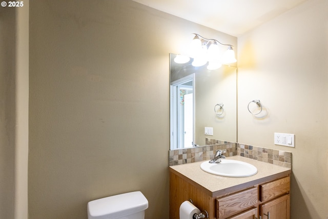 bathroom with tasteful backsplash, vanity, and toilet